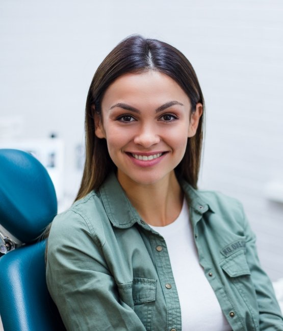 Woman in green shirt smiling in dental chair in Chicago dental office
