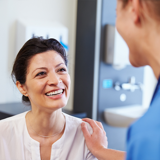 Dentist talking to patient and putting hand on their shoulder