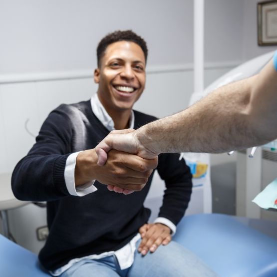 Smiling man shaking hands with his dentist