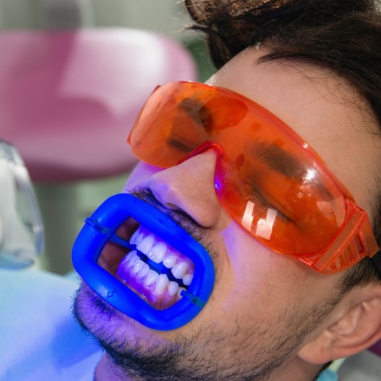 Man getting professional teeth whitening in dental office