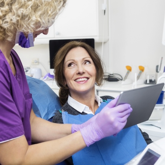 Cosmetic dentist showing a tablet to a patient