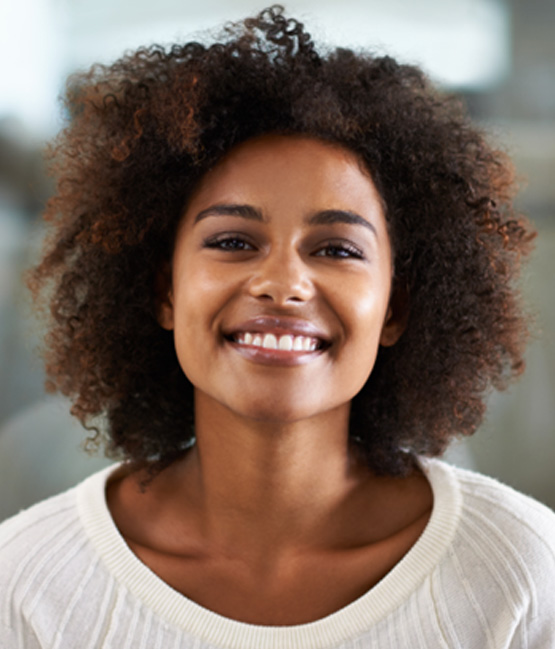 Close-up of woman in white sweater smiling