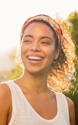 Woman with ponytail smiling outdoors