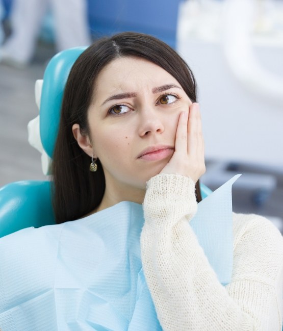 Woman holding her jaw in pain while visiting emergency dentist in Chicago