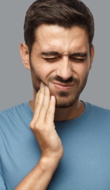 Man holding his cheek in pain