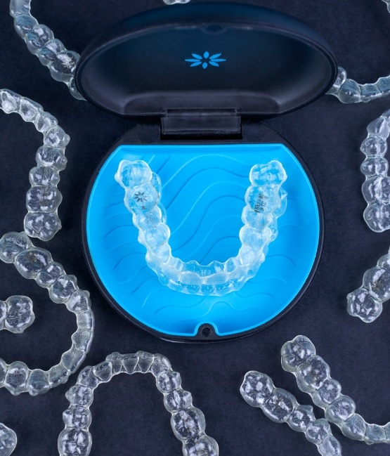 Several Invisalign clear aligners in Chicago on table with a carrying case