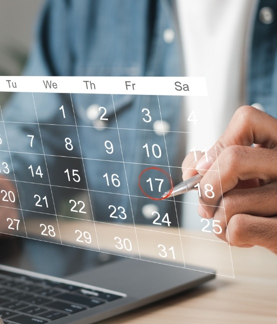 Person circling date on calendar for dental appointment