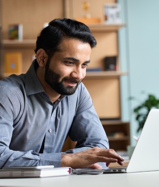 Man looking at laptop for dentist reviews in Chicago