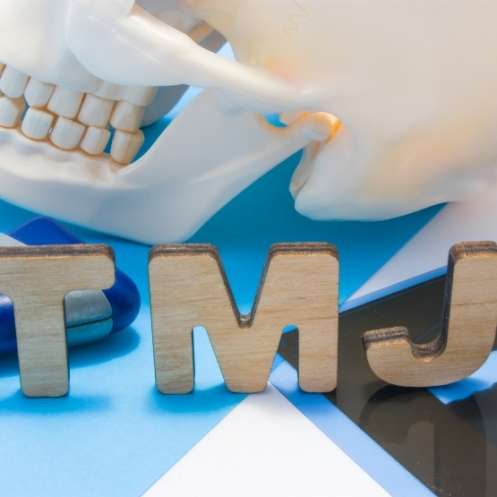 Wooden letters T M J on desk next to model of skull