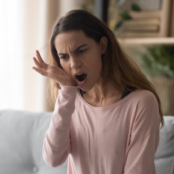 Woman holding the side of her jaw in pain