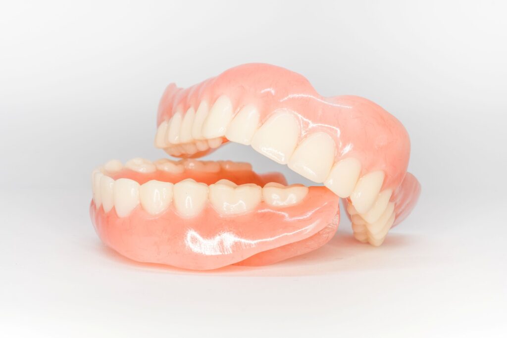 Complete set of dentures on white surface