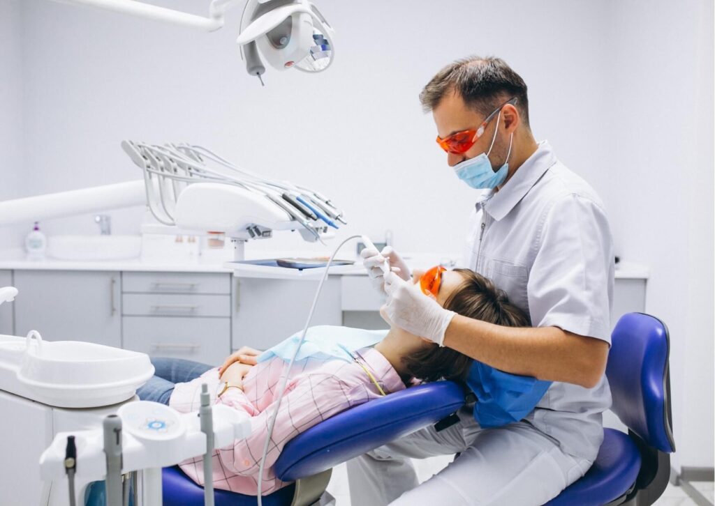 Dentist evaluating a patient’s smile during a cosmetic consultation for choosing bonding or veneers